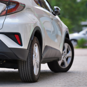 Close-up of a rear passenger tire on a white sedan.