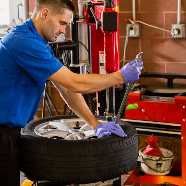 Technician works on new tire.