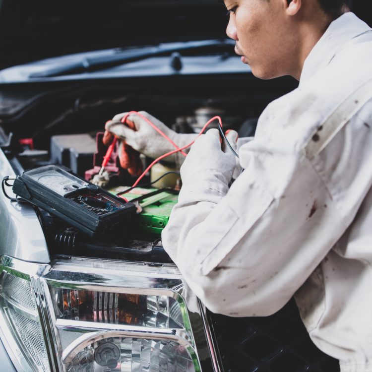 Auto tech performs testing on a car electrical system.